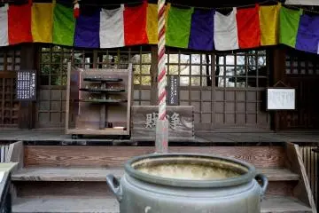 <p>Multi-colored curtains hanging above the temple doors</p>