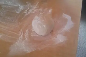 <p>After a bit of kneading you can turn your ball of dough out onto the table.</p>