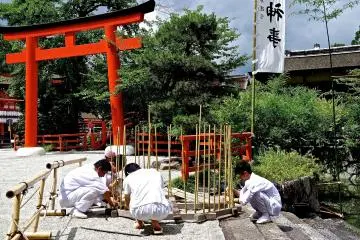 <p>Shinto priests making a wooden stand for a ceremony near Mitarashi-no-ike</p>