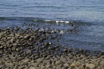 <p>Low lapping sounds among the stones of the shore</p>