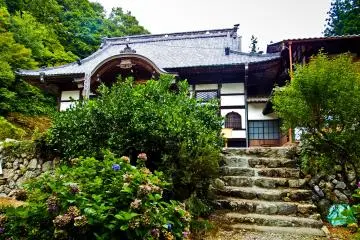 <p>Behind the statue of &lsquo;Oda Dokan&rsquo; you can see the main temple hall</p>
