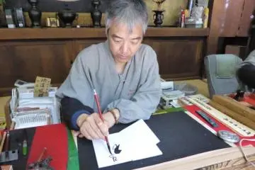 고야산 토로도 회관의 돌길을 따라 한 승려가 고슈인쵸 그림을 그리느라 분주하다.