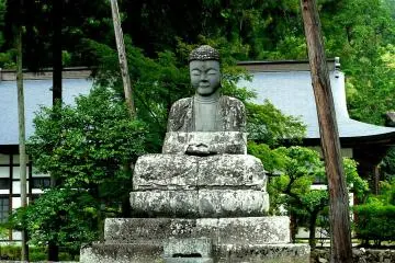 <p>A statue of Buddha meditating in the garden</p>