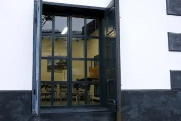<p>Small-paned windows with dark gray shutters</p>