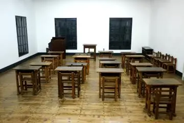 <p>Old wooden desks in neat rows &nbsp;</p>