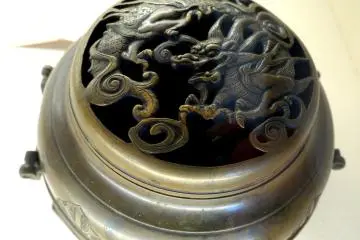 <p>Dragon motif on the cover of a small metal container</p>