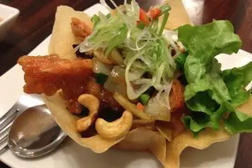 Stir fried chicken and cashew nuts served in a savory cracker bowl