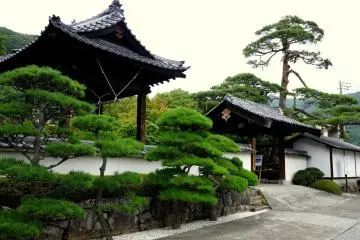 <p>The bell tower stands beside a gate</p>