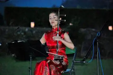 <p>นักดนตรีหญิงกำลังเล่นซอ erhu ในระหว่างการแสดงคอนเสิร์ต</p>
