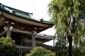 <p>Looking at the main temple building through green trees and the belfry</p>
