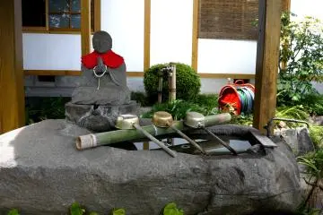 <p>Praying statue beside the water basin</p>