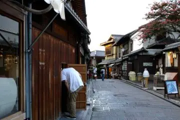<p>A restaurant worker ducks through a small door in the wooden wall</p>