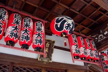 <p>Bright red lanterns hanging under one of the smaller shrines in the precinct</p>