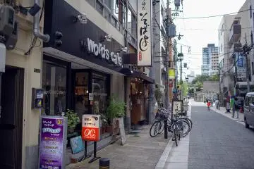 <p>The Words Cafe shopfront on the street, with the entrance to Osaka Tenmangu Shrine in the background</p>