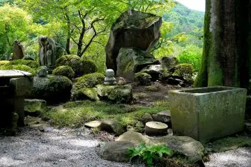 <p>A garden of mossy rocks and statues</p>