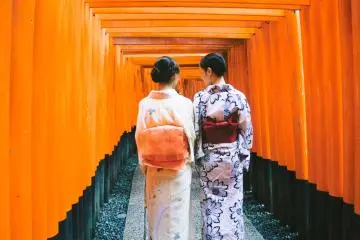 <p>Dua orang gadis Jepang yang berpakaian tradisional; kimono dan yukata, sedang berjalan di antara rubuan torii.</p>