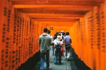 <p>Para pengunjung yang bergerombol melewati ribuan torii. Di antara torii tersebut dituliskan juga doa-doa dengan bahasa Jepang.</p>