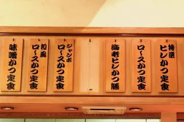 <p>Menu written on pieces of wooden board on the wall</p>