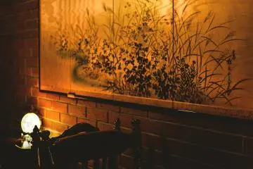 <p>Gold tinted Japanese artwork illuminating the back room</p>