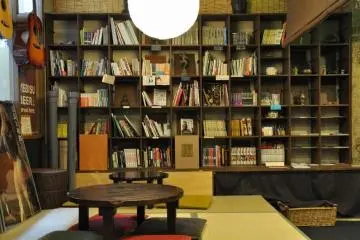 Ugaya Guesthouse's common area is stocked with books, souvenirs, and maps. (Photo: <a href="http://www.ugaya.net/en/facilities/photo/003.jpg" target="_blank" rel="noreferrer noopener nofollow">Ugaya Guesthouse</a>)