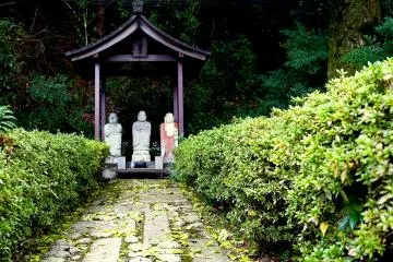 <p>Three small statues at the end of a small, rough path</p>