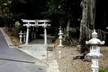 Stone torii and lanterns at the entrance to Rokusho Shrine