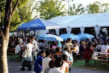 <p>축제 때 사람들이 앉아서 마시고 먹을 수 있도록 많은 테이블과 의자들이 준비되어 있다.</p>