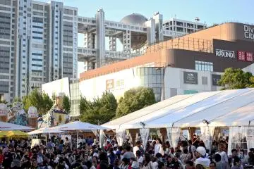 <p>이 축제는 오다이바에 있는 다이버 시티 몰(Diver City Mall)과 굉장히 가까운 곳에서 한다 - 후지 방송국 건물과 함께 배경으로 보일 정도로.</p>