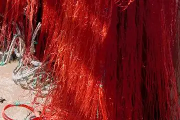 Red netting hanging out to dry.