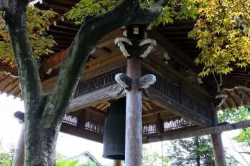 <p>Struktur rangka kayu menara lonceng yang rumit, serta dedaunan indah yang berubah warna kuning</p>