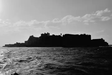 <p>The silhouetted Gunkanjima in B &amp; W viewed from southeast</p>