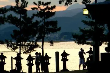 <p>People and lanterns silhouetted against the water</p>