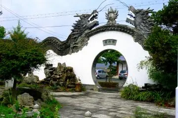 <p>Two dragons meet above a circular gate</p>