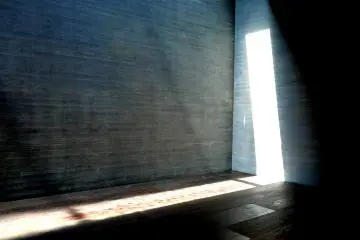 <p>A tall narrow window creates a slash of light</p>
