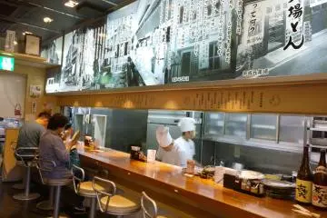 <p>บรรยากาศร้านที่บริเวณชั้นหนึ่งซึ่งเป็นการตกแต่งในกลิ่นอาย Modern Contemporary เป็นความร่วมสมัยของความเก่าผสานความใหม่ เค้าเตอร์ไม้ที่วางตลอดแนวครัวเปิดนั้นทำให้เราเห็นการทำมิโซะคัตสึที่สดใหม่ทุกขั้นตอน ช่วยให้ทุกคำของเรานั้นอร่อยอย่างลึกซึ้งขึ้น มุมนี้เหมาะสำหรับผู้ที่มาคนเดียวหรืออยากสัมผัสครัวอร่อยอย่างใกล้ชิด แต่ถ้าหากมากันหลายคนก็สามารถขึ้นไปใช้บริการที่ชั้นสองได้</p>