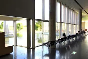 <p>Some visitors are relaxing in a chair looking out at the beautiful pond</p>