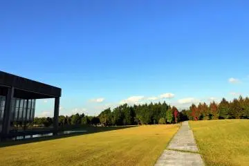 <p>Long walkway stretches out into a forested garden park</p>