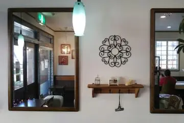 <p>On the shelf is a shoe made of pastry; the mirrors help fill the cafe with natural light</p>