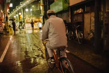 <p>Man biking towards the shopping arcade.</p>