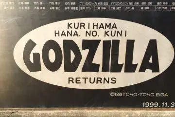 <p>A close-up view of the sign on Godzilla's pedestal at Kurihama&nbsp;Flower World</p>