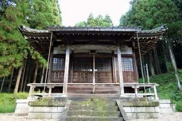 <p>Front view of the prayer hall standing silently in the woods</p>