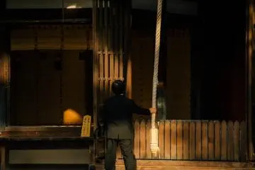 Un homme sonne la cloche en faisant une prière