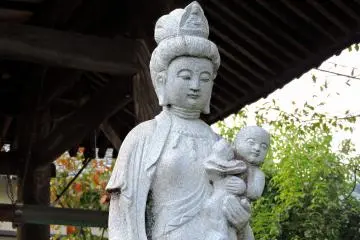 어린이들을 위한 자선 여신상을 자세히 살펴봐라. 그녀가 안고 있는 아기는 매우 행복해 보인다!