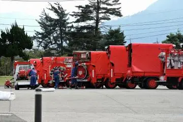 <p>Many red fire trucks were parked in the open space</p>