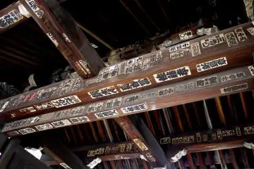 <p>Pilgrim stickers on the wooden roof beams of the gate</p>
