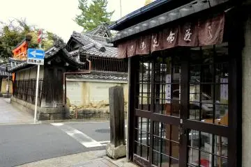 <p>A quaint shop on the street corner opposite with the shrine in the background</p>