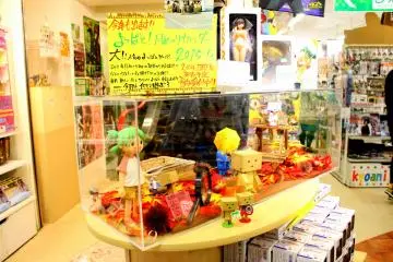 <p>Anime figure toys are all over the place. Some are in glass display cases while others are on the shelves.</p>