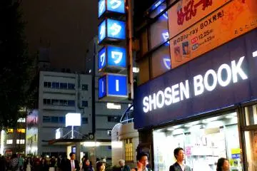 <p>Several Akiba locals and expatriates walk past the bookstore's main entrance</p>
