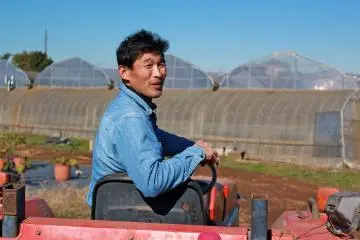 <p>Furito Yokota, part owner of Yokota Farm, takes a minute to answer questions the tour group has</p>