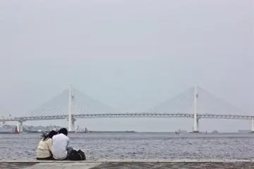 A couple enjoying the view of the Yokohama Bay Bridge.